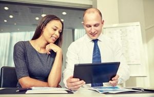 two young business owners reviewing their SEO program and website on a tablet