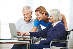 daughter helping senior couple view senior living community website on computer