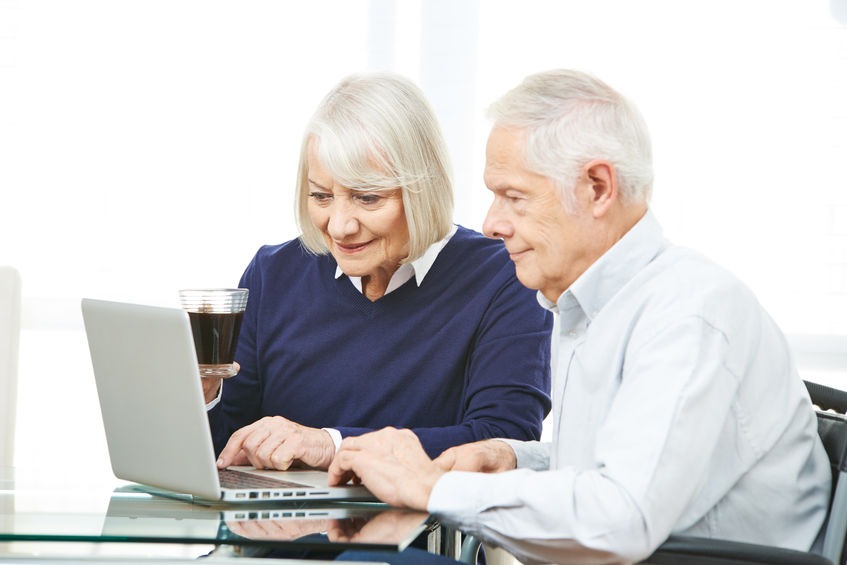 Senior couple with computer surfing the internet