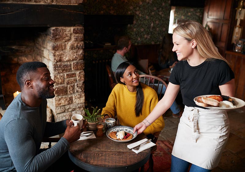 Waitress serving food to couple