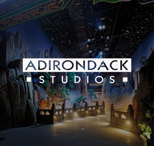Adirondack Studios logo with one of their sets in the background.