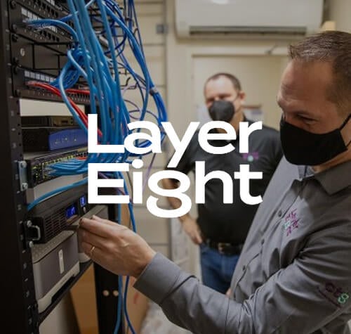 Layer Eight logo with employees working on wiring in the background.