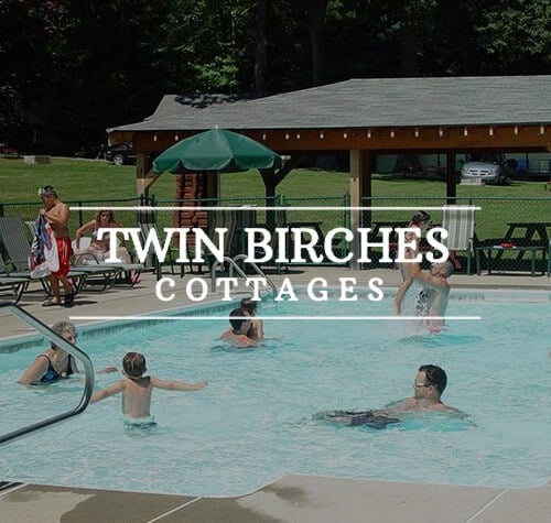 Twin Birches Cottages logo with their pool in the background.