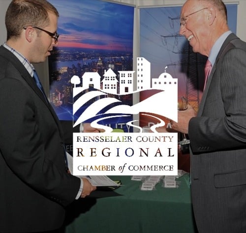 Rensselaer County Regional Chamber of Commerce logo with men wearing suits in the background.