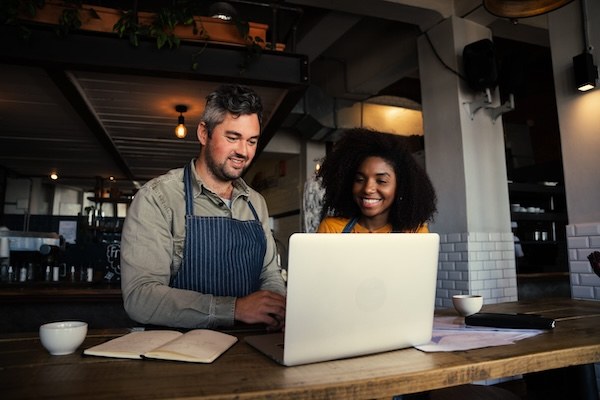 Man and woman using a computer in a coffee shop